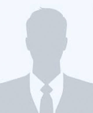 A gray silhouette of a person wearing a suit and tie, shown against a light gray background, typically used as a placeholder profile image.