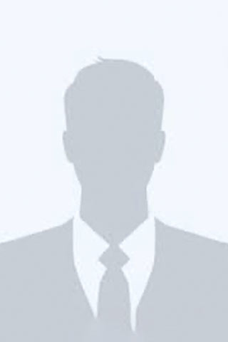 A gray silhouette of a person wearing a suit and tie, shown against a light gray background. The image is often used as a placeholder for a profile photo.